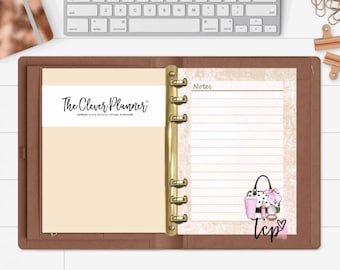 May include: A brown leather bound planner with gold rings. The left page has a white label with the text "The Clever Planner" and the right page has the text "Notes" at the top and a lined section for writing. The right page also has a sticker with a black and white polka dot handbag, a pink coffee cup, a pink lipstick, and a pink heart with the text "tcp" in black.