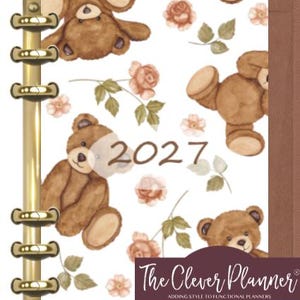 May include: A planner with a gold-toned metal six-ring binder mechanism and a white cover featuring a repeating pattern of brown teddy bears and peach-colored roses. The year 2027 is printed in brown, and a dark purple label reads The Clever Planner.