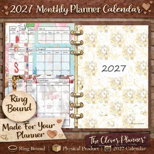 May include: A ring-bound 2027 monthly planner calendar. The planner features a brown cover with gold accents and a patterned design. Inside, there are monthly calendar pages with various decorative elements. The text "2027" is prominently displayed.