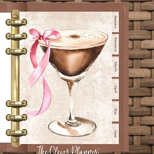Puede incluir: Una agenda marrón y beige con un encuadernador de anillos dorados. La portada presenta una ilustración de acuarela de una copa de martini con una cinta rosa y un lazo. Los meses del año están listados en el lado derecho de la portada: enero, febrero, marzo, abril, mayo, junio. El texto "The Clever Planner" está en la parte inferior de la portada.