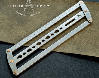 May include: A silver metal leather working tool with a ruler and various hole sizes. The tool is hinged and has copper-colored rivets. The text "ARTISAN LEATHER SUPPLY" and "ARTISANLEATHERSUPPLY.COM" are visible.