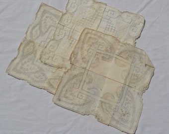 Puede incluir: Tres pañuelos de lino blanco con delicados diseños bordados. Los pañuelos están doblados y superpuestos.
