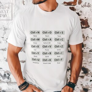 May include: White t-shirt with keyboard shortcut commands printed in gray. The commands include "Ctrl+N New", "Ctrl+O Open", "Ctrl+S Save", and more. The shirt also has the text "white" printed on it.