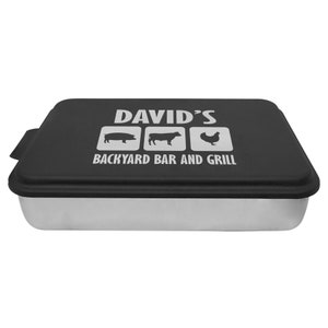 May include: Black metal baking pan with a removable lid. The lid has a white design that says "DAVID'S BACKYARD BAR AND GRILL" with icons of a pig, cow, and chicken.