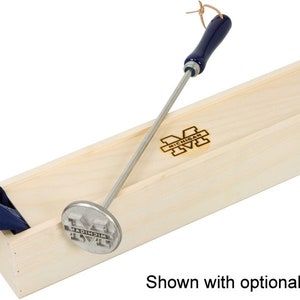 May include: A silver metal branding iron with a blue wooden handle and the University of Michigan logo. The branding iron is in a wooden box with the University of Michigan logo.