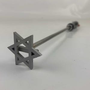 May include: A metal branding iron with a Star of David design. The iron is attached to a long metal rod.