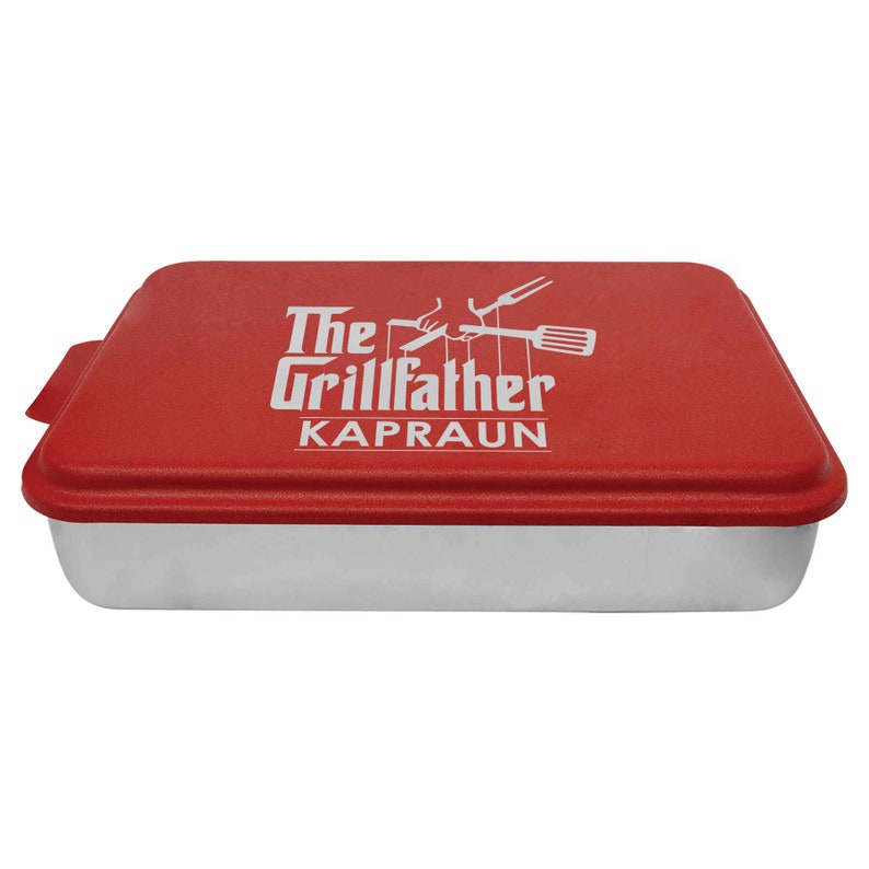 May include: Red baking pan with a silver interior and a red lid. The lid has a white logo that says "The Grillfather Kapraun" with a graphic of a hand holding a spatula and a fork.