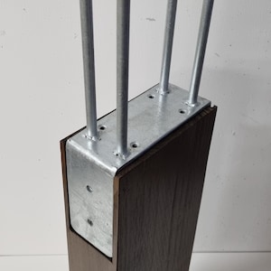 May include: A dark brown wooden furniture leg with four silver metal hairpin legs attached to a metal plate. The leg is rectangular and has a modern design.