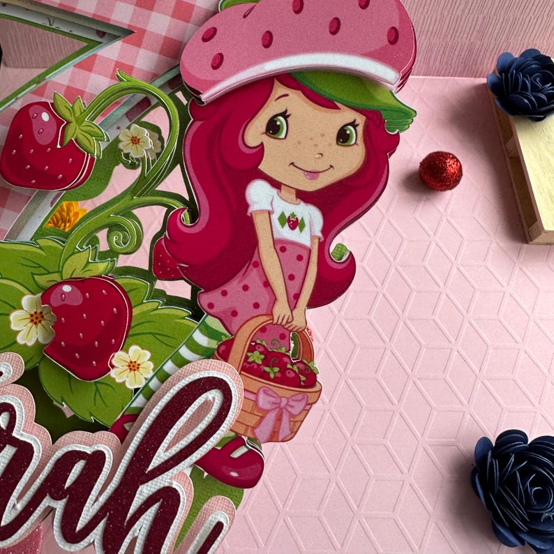 May include: A red and white strawberry character with a basket of strawberries. The character is holding a basket of strawberries and has a pink and green hat. The character is standing on a pink background with a white and pink checkered pattern.