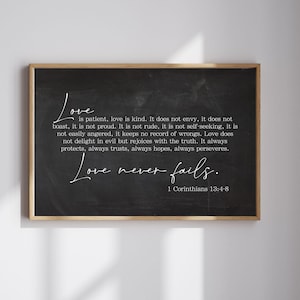 May include: A framed chalkboard print with the words "Love is patient, love is kind" in white script. The print includes the Bible verse 1 Corinthians 13:4-8. The frame is a natural wood colour.