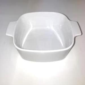 May include: A square, white ceramic baking dish with two handles. The dish has a slightly rounded interior and is set against a white background. The dish is designed for baking and serving.