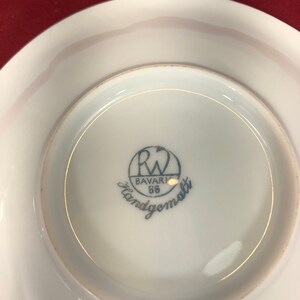 May include: A white porcelain saucer with a blue and white logo that reads "R.W. Bavaria 66 Handgemalt".