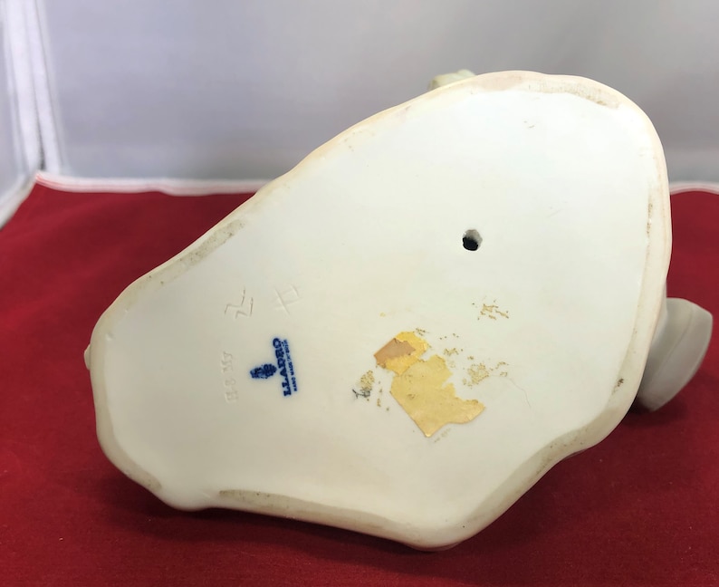 May include: White porcelain figurine with a blue and white Lladro mark on the bottom. The mark includes the number 5528 and the text "Lladro, Spain".