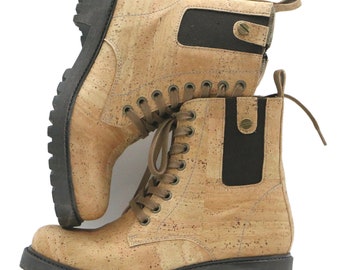 May include: A pair of cork and black leather ankle boots with laces. The boots have a brown cork upper and a black rubber sole.