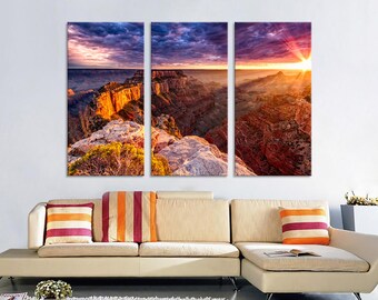 May include: A panoramic view of the Grand Canyon at sunset, with vibrant purple, orange, and pink hues in the sky. The sun is setting behind the canyon, casting a golden glow on the rock formations.