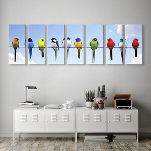 May include: Eight colorful birds perched on a wire against a light blue sky. The birds are red, yellow, blue, green, and black and white.  The birds are arranged in a row on a wall-mounted canvas print, ideal for home decor or as a vibrant piece of art. The multi-panel canvas features a nature theme and bright colors.