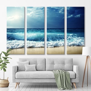 K&ouml;nnte beinhalten: Ein vierteiliger Leinwanddruck mit einer Meereslandschaft, auf der blaue Wellen an einem Sandstrand brechen. Der Himmel ist eine Mischung aus Blau und Grau mit Wolken.