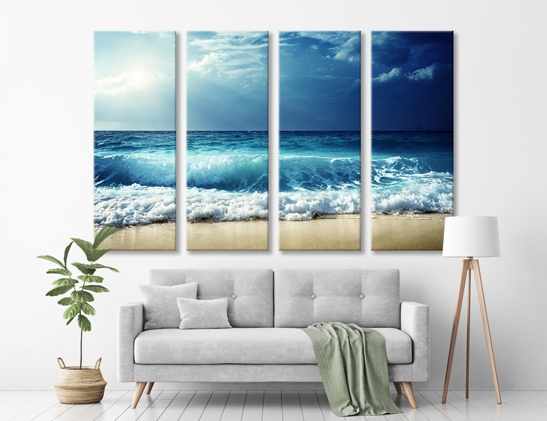 K&ouml;nnte beinhalten: Ein vierteiliger Leinwanddruck mit einer Meereslandschaft, auf der blaue Wellen an einem Sandstrand brechen. Der Himmel ist eine Mischung aus Blau und Grau mit Wolken.