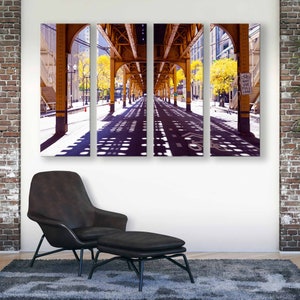May include: A three-panel canvas print of a city street under a yellow bridge. The street is lined with trees and the shadows of the bridge create a pattern on the pavement. The sign on the right side of the image reads "May Use Full Lane".