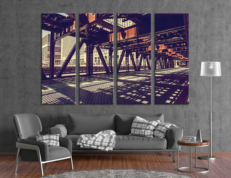May include: A tri-panel canvas print of a city street scene with a bridge overhead. The bridge is made of metal and has a grid pattern. The buildings in the background are tall and modern. The image is in a vintage style with a faded color palette.
