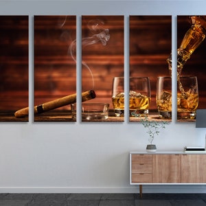 May include: A multi-panel canvas print featuring a wooden background with three glasses of amber liquid, a lit cigar, and a bottle pouring liquid into one of the glasses.