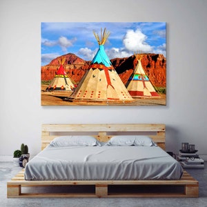 May include: Three colorful teepees stand against a backdrop of red rock formations and a blue sky with white clouds. The teepees are decorated with geometric patterns and symbols in shades of red, blue, yellow, and white.