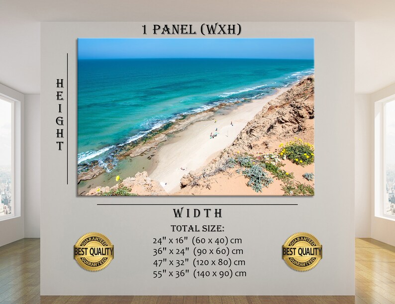 May include: A canvas print of a coastal landscape featuring a turquoise ocean, sandy beach, and rocky cliffs under a clear blue sky. The print is displayed on a white wall, with text indicating various size options in inches and centimeters.