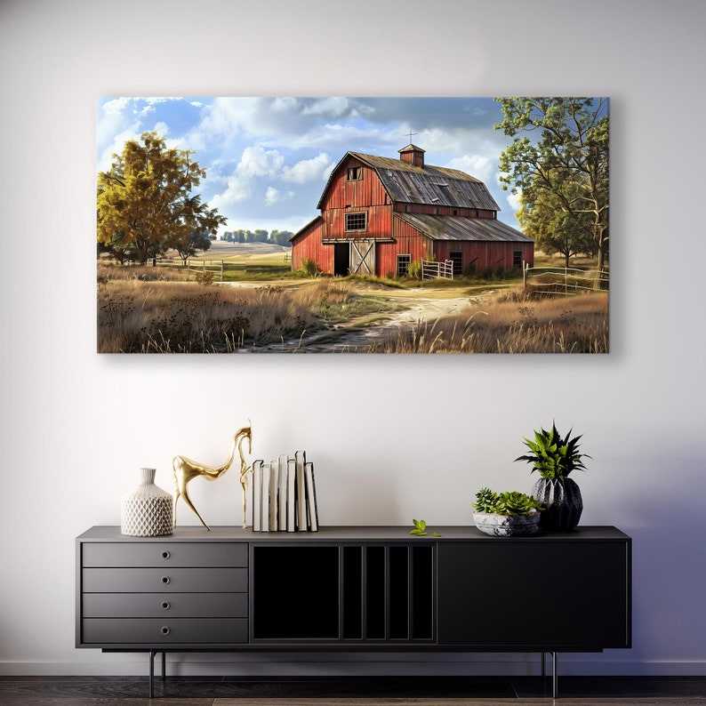 May include: A rectangular canvas print depicts a rural landscape with a red barn under a cloudy sky. The barn, with a weathered appearance, is the focal point, surrounded by fields and trees. The artwork is displayed above a black cabinet.
