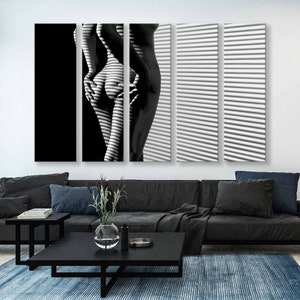 Puede incluir: Una fotograf&iacute;a en blanco y negro de una persona de pie frente a una ventana con persianas. El cuerpo de la persona est&aacute; parcialmente oscurecido por las sombras proyectadas por las persianas.