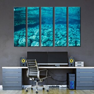 May include: Five-panel wall art featuring an underwater scene with turquoise water and rocks. The artwork is displayed above a modern desk with a computer setup, speakers, and a black office chair. The overall aesthetic is contemporary and serene.
