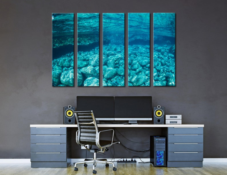 May include: Five-panel wall art featuring an underwater scene with turquoise water and rocks. The artwork is displayed above a modern desk with a computer setup, speakers, and a black office chair. The overall aesthetic is contemporary and serene.