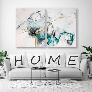 May include: Two abstract art prints with a white background and teal and gold accents. The prints are titled "HOME" with black lettering.