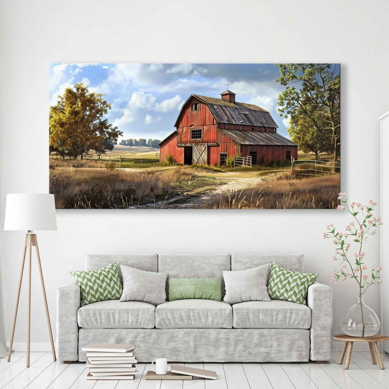 May include: A large rectangular canvas print depicts a rural landscape with a red barn as the focal point. The barn has a weathered appearance, with a dark roof and visible wooden doors. The surrounding area features fields, trees, and a cloudy sky.