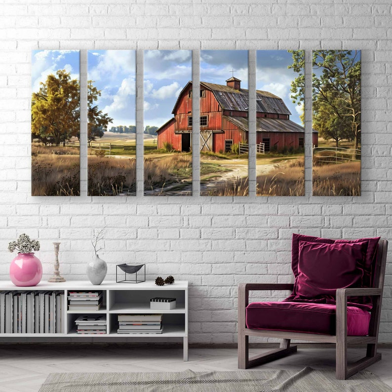 May include: A multi-panel canvas print depicting a rural landscape with a red barn under a cloudy sky. The artwork features a dirt path leading to the barn, surrounded by fields and trees. The print is displayed on a white brick wall, with a modern white cabinet and a burgundy armchair.