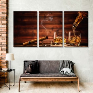 May include: A three-piece canvas print set featuring a wooden background with two glasses of whiskey and a lit cigar. The whiskey is being poured from a bottle into one of the glasses.