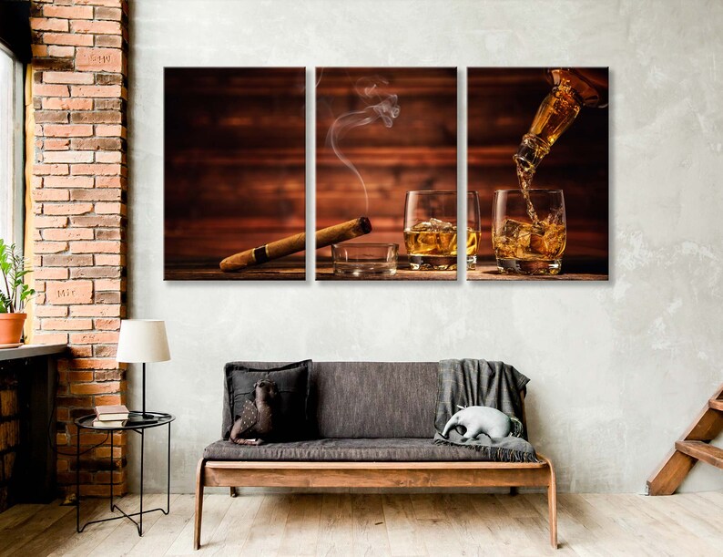 May include: A three-piece canvas print set featuring a wooden background with two glasses of whiskey and a lit cigar. The whiskey is being poured from a bottle into one of the glasses.