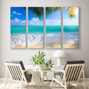 May include: A three-panel canvas print depicting a tropical beach scene. The image features a turquoise ocean with white foamy waves crashing on a sandy shore. Palm tree leaves are visible in the foreground, creating a sense of depth and tranquility.