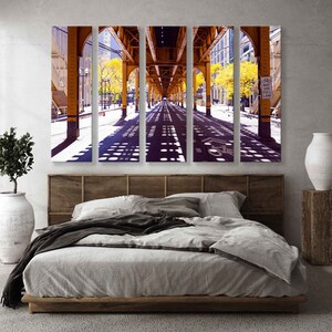 May include: A four-panel canvas print of a city street under a yellow elevated train track. The street is lined with trees and the shadows of the train track create a pattern on the pavement. The sign on the right side of the image reads "May Use Full Lane".