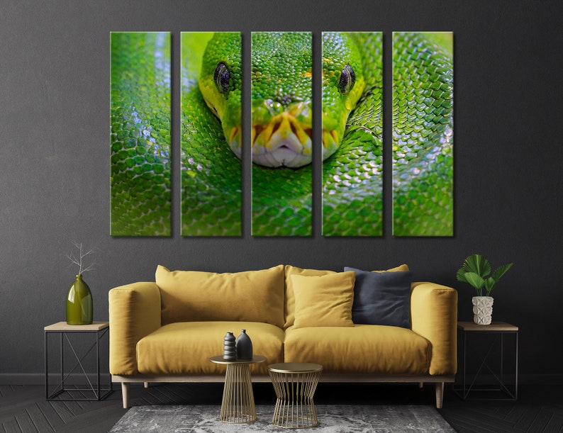 May include: A close-up of a green snake's head with its eyes open and mouth closed. The snake is wrapped around a branch or log, and its scales are visible. The background is a dark green.