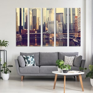 May include: A multi-panel canvas print featuring a cityscape with tall buildings, a river, and a bridge. The image is in a vintage style with warm colors and a soft focus.