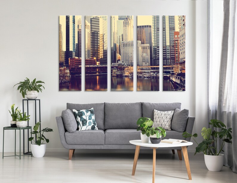 May include: A multi-panel canvas print featuring a cityscape with tall buildings, a river, and a bridge. The image is in a vintage style with warm colors and a soft focus.