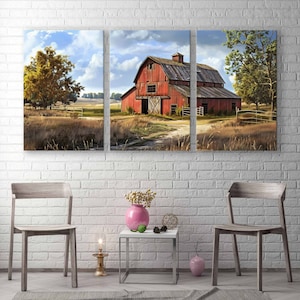 May include: A triptych canvas print depicting a rural landscape with a weathered red barn as the focal point. The barn is surrounded by fields, trees, and a dirt path. The artwork is displayed above a small table with a pink vase and two wooden chairs.