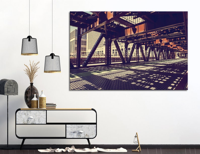 May include: A vintage photograph of a metal bridge over a city street. The bridge is made of steel beams and has a grid pattern on the surface. The photo is taken from below the bridge, looking up at the underside.