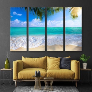 May include: A tri-panel canvas print depicting a tropical beach scene with turquoise water, white sand, and palm tree leaves.