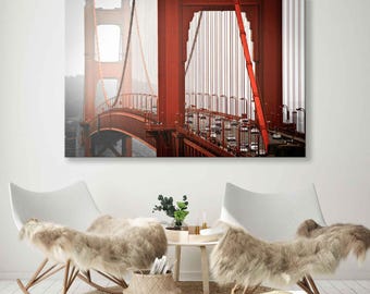 Pode incluir: Uma fotografia da Ponte Golden Gate em São Francisco, Califórnia. A ponte é vermelha e tem um grande arco. A ponte está cercada por nevoeiro e há carros a atravessá-la.