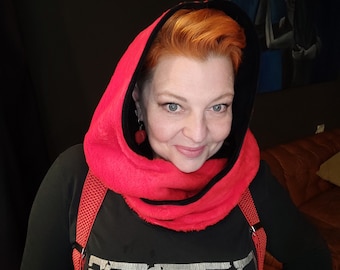 May include: A red hooded scarf with a black interior lining. The scarf is worn over a black shirt with the word "READY" printed on it. Red suspenders are visible.