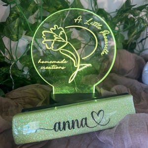 May include: A Little Jazarella LED light with a floral design and the words "homemade creations". A glittery green rectangular base has the name "anna" and a heart symbol in black script.