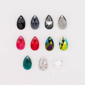 May include: A collection of teardrop-shaped crystal pendants in various colors, including black, gray, red, and iridescent. Each pendant has a small hole at the top for stringing. The crystals are displayed against a white background.
