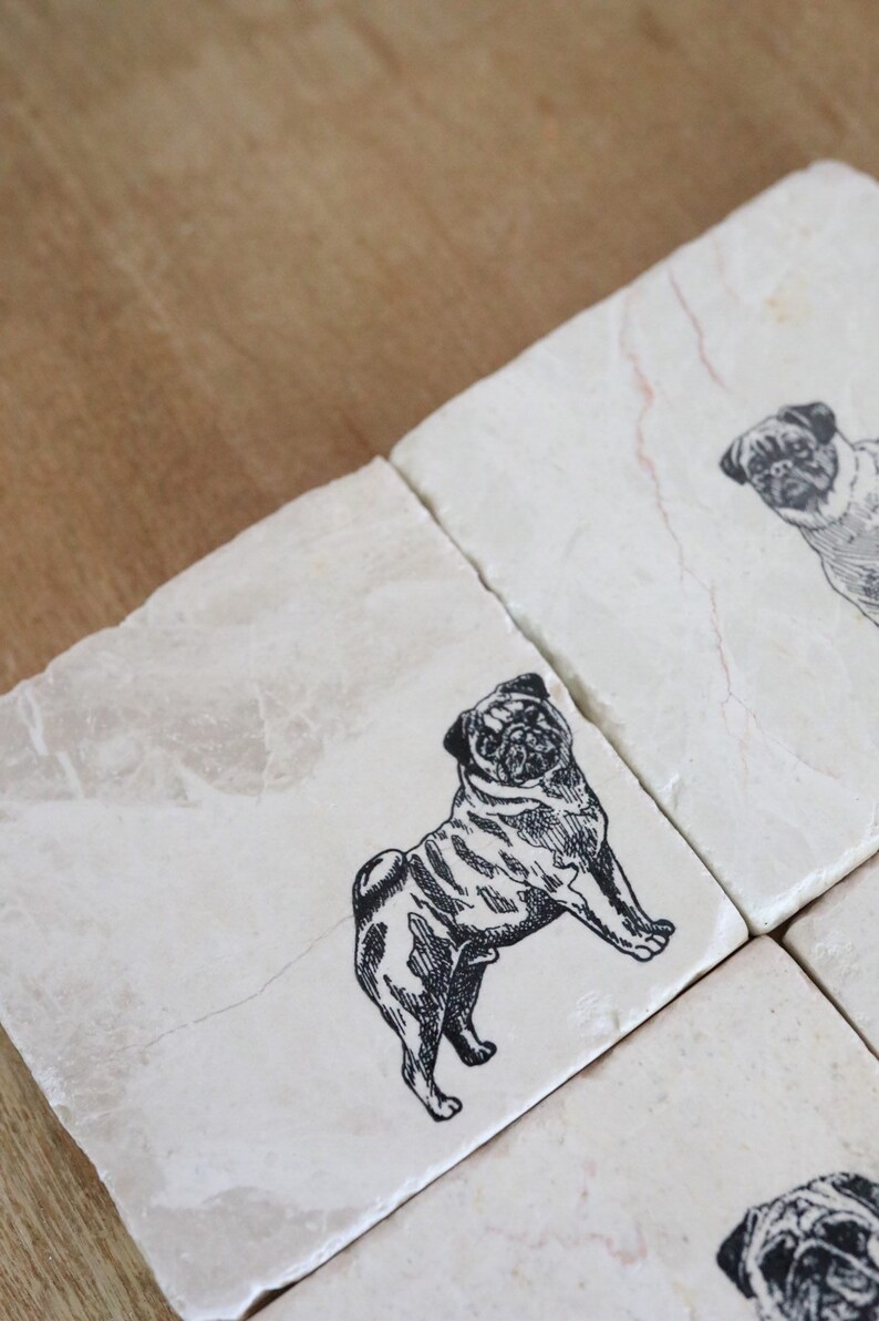 May include: Set of four white marble coasters with black and white pug illustrations.