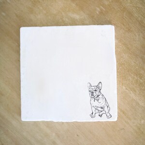 May include: Square white coaster featuring a black and white illustration of a French Bulldog. The dog is sitting, with its ears perked up. The coaster has a slightly rough, textured edge.